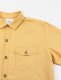Particolare del colletto giallo della camicia da lavoro