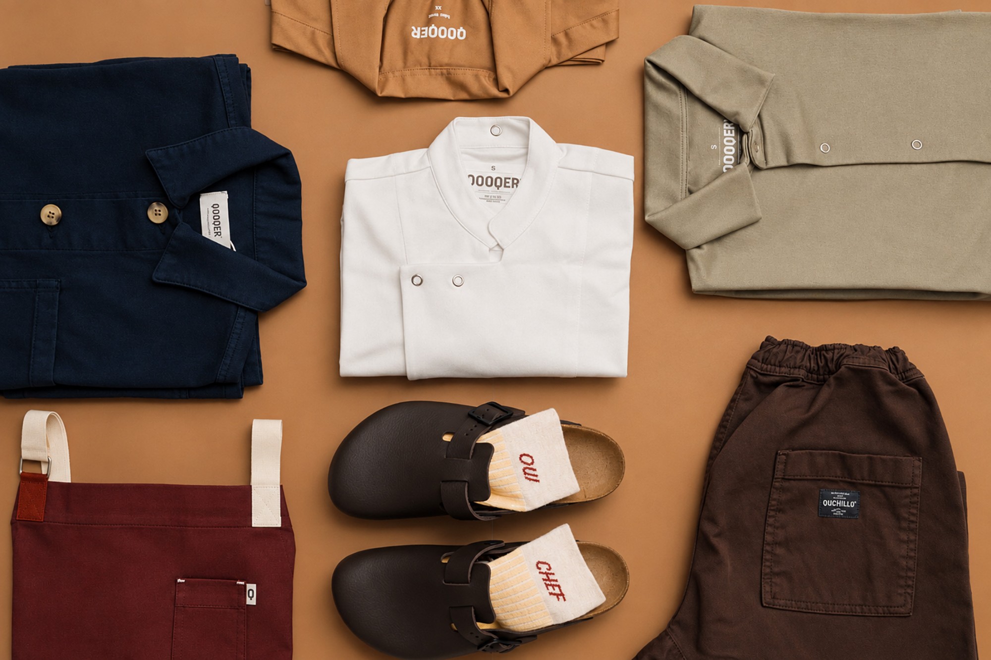 Uniforme de hostelería completo: chaqueta azul marino, chaquetilla blanca, polo verde, delantal burdeos, pantalón marrón y zuecos Uniforme de hostelería completo: chaqueta azul marino, chaquetilla blanca, polo verde, delantal burdeos, pantalón marrón y zuecos